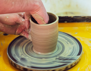 Master class on making a ceramic pot with a Potter's wheel. The pottery is rotating around its axis.