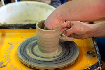 Master class on making a ceramic pot with a Potter's wheel. The pottery is rotating around its axis.