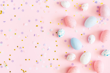 Easter composition. Easter eggs, confetti on pastel pink background. Flat lay, top view, copy space