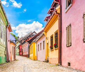 Old medieval cobblestone stree with colorful houses in Sighisoara, Transylvania, Romania