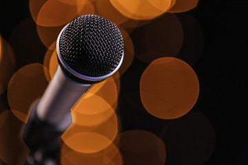Microphone against dark background with defocused lights