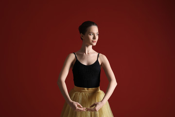 Beautiful young ballerina on color background