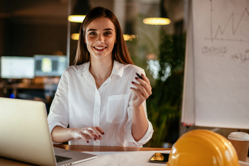Young woman architect working on a project. Female engineer at her desk.