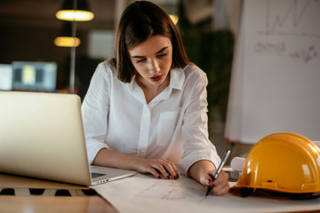 Young woman architect working on a project. Female engineer at her desk.
