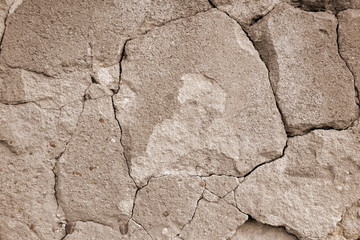 Old cracked and partially collapsed plaster. Sepia toned. Close-up. Selective focus.