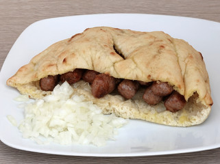 Grilled dish of minced meat called cevapcici in buns with onion