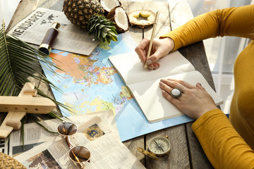 Young woman with world map choosing country to spend her vacation
