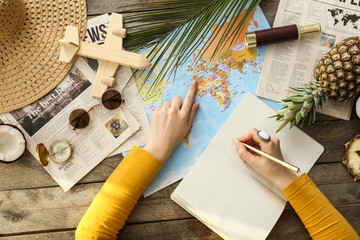 Young woman with world map choosing country to spend her vacation