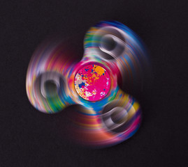 Fidget finger spinner stress, anxiety relief toy on a black background