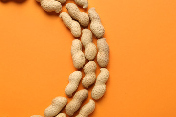 Tasty peanuts on color background