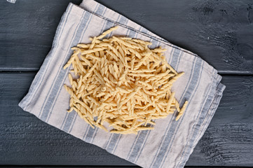 Dark photo of homemade pasta Trofie from Liguria . Italian healthy food concept with copy space. Soup with homemade pasta and meat.