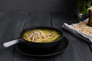Dark photo of homemade pasta Trofie from Liguria . Italian healthy food concept with copy space. Soup with homemade pasta and meat.