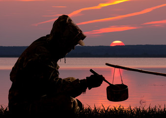 hunter eating out of the pot at sunset