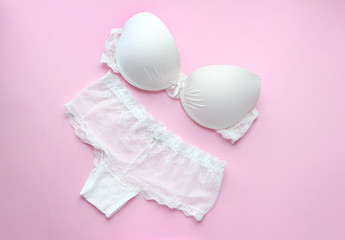 White sexy lingerie set on pink background.Top view.Lace bra and  panties on pink background.