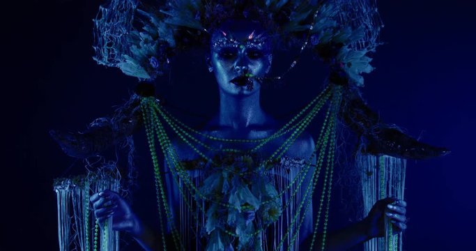 Portrait of beautiful female with complex floral make-up posing in creative lighting. Body painting fashion project. Model and property released. 4K UHD RAW FOOTAGE