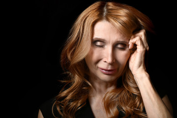 Obraz premium Sad mature woman on dark background