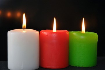 Fototapeta na wymiar colorful burning candles set on black background.