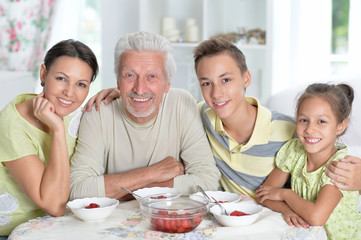 Portrait of a happy family eating fresh strawberries