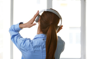 Naklejka premium Young woman listening to music at home