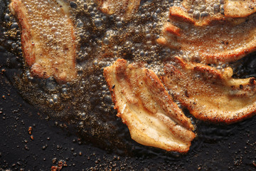 frying pan with meat on fire