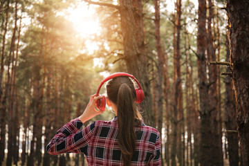 Young woman listening to music in forest