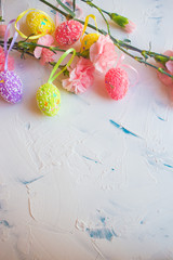  Easter eggs and flowers on a light background. Holiday card for Easter. Colored eggs and pink flowers