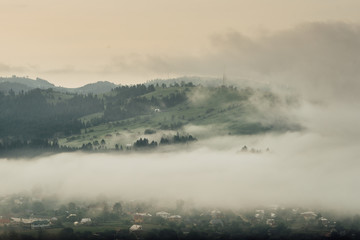 The fog in the valley of the village between the mountains