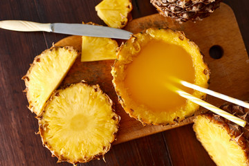 Fresh fruit juice with exotic pineapple on a wooden brown table. A composition made of ananas. Top wiev. 