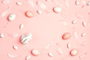 Easter pink background with decorative bunny, eggs feathers and copy space.