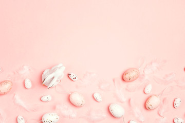 Easter pink background with border of decorative bunny, eggs, feathers and copy space.