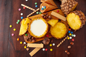 Milk pineapple drink on a wooden brown table. Summer ice cream and cocktails set. Top view