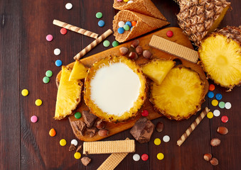 Milk pineapple drink on a wooden brown table. Summer ice cream and cocktails set. Top view