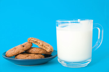 cookies and glass of milk on blue background. oatmeal cookie with pieces of chocolate