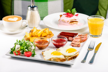 Huge healthy breakfast spread on a table with coffee, orange juice, fruit, muesli, smoked salmon, egg