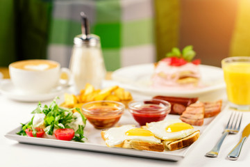 plate of breakfast food with bacon, eggs, toast, and fried potatoes