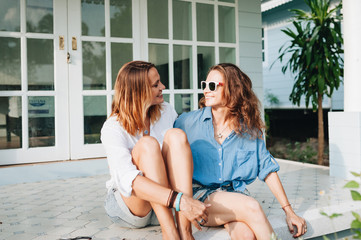 Happy lesbian couple sitting on terrace at their country house