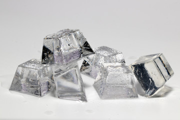 Transparent ice cubes melted on a white background.