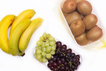 Mix of fruits in baskets from the top. Bananas, Kiwi and Grapes
