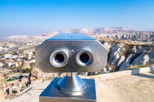 Stationary binoculars or binoscope on the viewing platform aimed at the mountains of Cappadocia, Turkey. Front view.
