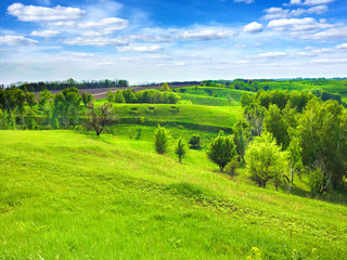 Picturesque hilly landscape with bright blue cloudy sky