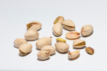 Peeled and unpeeled pistachio nuts isolated on white background