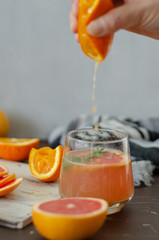 Grapefruit and oranges are on the wooden table.