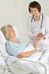 Obraz premium Close up portrait of senior woman portrait in hospital with caring doctor