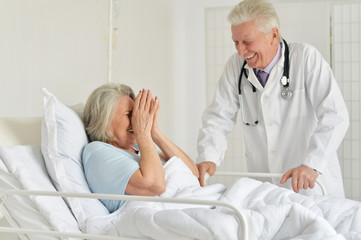 Fototapeta premium Portrait of happy senior woman in hospital with caring doctor