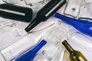 Reduce reuse recycle. Sorting waste. Empty colorful glass bottles are prepared for recycling on dark background. Protect the environment. Top view