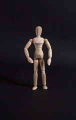 Wooden mannequin. Wooden man. Wooden mannequin on a black background.