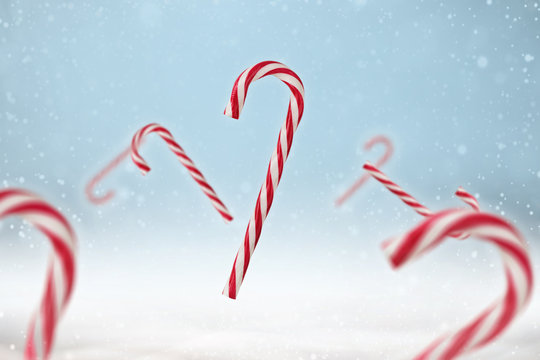 Red And White Candy Cane On A Blue Snowy Background.