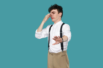 Confused man showing stop and pinching his nose.