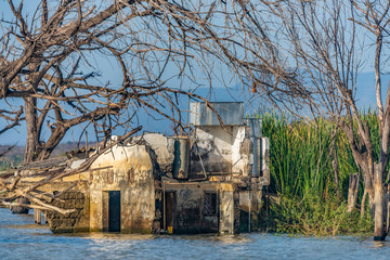 Fototapeta na wymiar Abandoned, partially submerged buildings, on foreshore of Lake Baringo, Kenya.Water in Rift Valley lakes has risen since 2011.Possible reasons, climate change, tectonic movement, deforestation, rains.