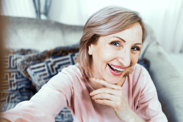 Selfie of charming and smiling mature woman